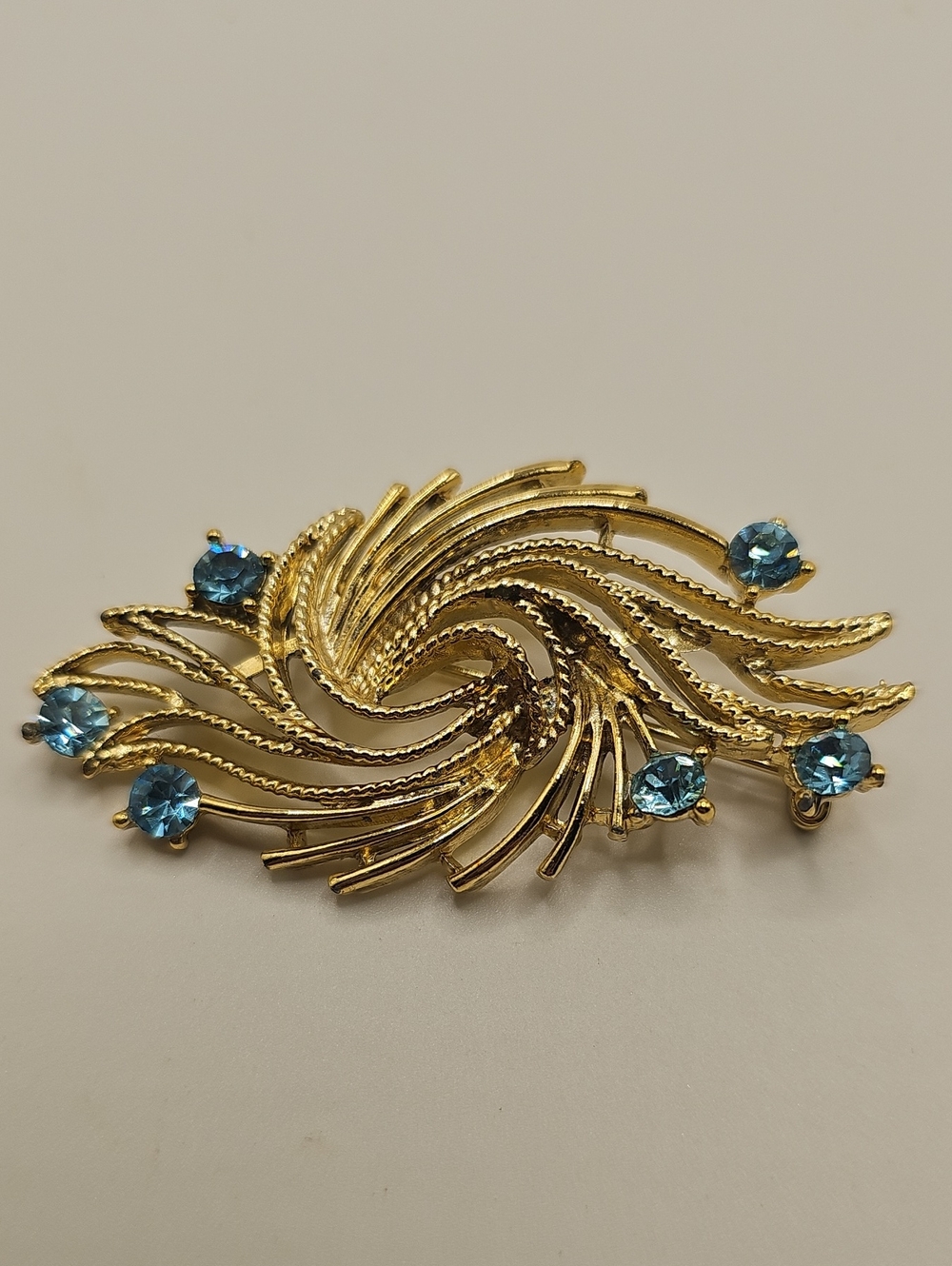 Gold-Tone Swirl Brooch with Blue Crystal Accents